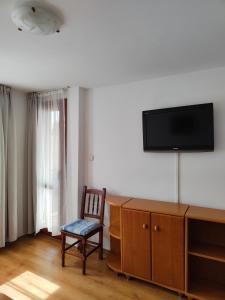 a room with a chair and a tv on a wall at Guest Rooms Melsambria in Nesebar