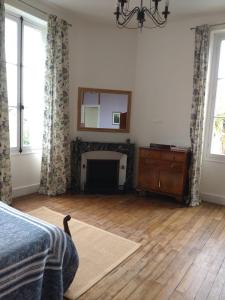 a bedroom with a fireplace and a mirror on the wall at La brasserie chambre d'hotes de Delphine in Saulgé