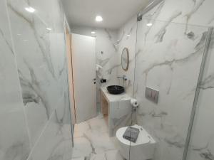 ein Bad mit einer Dusche, einem WC und einem Waschbecken in der Unterkunft Rigas Hotel Skopelos in Skopelos