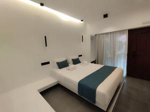 ein Schlafzimmer mit einem großen Bett in einem weißen Zimmer in der Unterkunft Rigas Hotel Skopelos in Skopelos