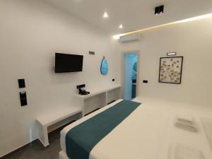 a bedroom with a bed and a tv on the wall at Rigas Hotel Skopelos in Skopelos Town