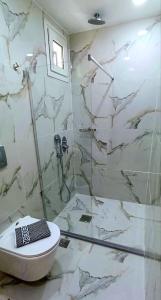 e bagno con doccia, servizi igienici e lavandino. di Rigas Hotel Skopelos a Skopelos Town