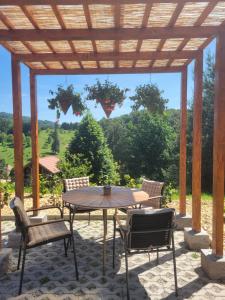 a patio with a table and chairs under a wooden pergola at Chalet -VV in Podčetrtek