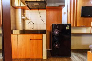 a small kitchen with a refrigerator and a sink at Pelangi Rooms By Reccoma in Pondokcabe Hilir