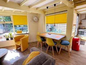 una sala da pranzo con tavolo, sedie e orologio di Happy Little Maya Bee a Nieuwe-Niedorp Altre 23 foto
