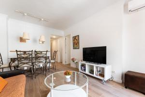 - un salon avec un canapé, une télévision et une table dans l'établissement MalagaSuite Malagueta Beach & Sun, à Malaga
