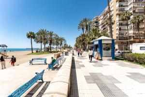 un arrêt de bus sur une plage bordée de palmiers dans l'établissement MalagaSuite Malagueta Beach & Sun, à Malaga