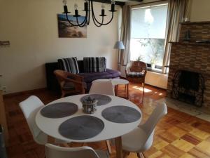 ein Wohnzimmer mit einem Tisch, Stühlen und einem Kamin in der Unterkunft Ferienwohnung Annika mit Sauna in Zinnowitz