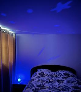 ein Schlafzimmer mit einem Bett mit blauer Decke in der Unterkunft Red Rose of Summer Flat with private garden - Wilena Holiday Home in Chens-sur-Léman