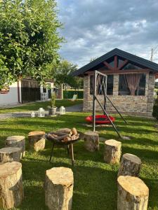 a fire pit in a yard with some logs at Holiday Home TimeOut Bizovac in Bizovac