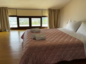 ein Schlafzimmer mit einem großen Bett mit zwei Handtüchern darauf in der Unterkunft Villa Theodora Skiathos in Skiathos-Stadt