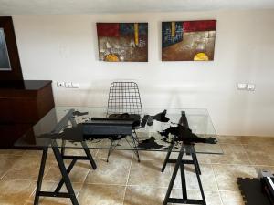 einen Glastisch in einem Zimmer mit Gemälden an der Wand in der Unterkunft Villa Theodora Skiathos in Skiathos-Stadt