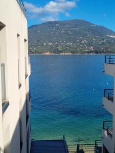 einen Blick auf einen großen Wasserkörper zwischen zwei Gebäuden in der Unterkunft MAGNIFIQUE APPARTEMENT LES PIEDS DANS L'EAU PROPRIANO in Propriano