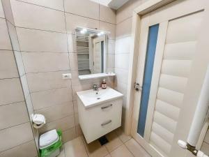La salle de bains est pourvue d'un lavabo et d'un miroir. dans l'établissement Black Sea Booking-London, à Mamaia Nord – Năvodari