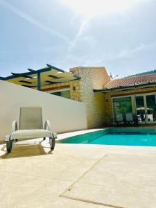 a chair sitting on a patio next to a swimming pool at Angello Villas in Agios Nikitas