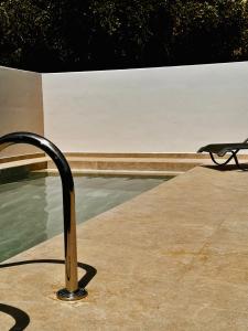 a bench sitting next to a pool of water at Angello Villas in Agios Nikitas
