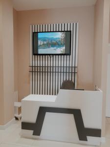 Habitación con mesa blanca y TV en la pared. en Hotel Restaurant Univers en Shkodër