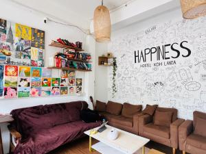 a living room with a couch and a table at Happiness Hostel in Phra Ae beach