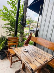 Happiness Hostel في Phra Ae beach: طاولة نزهة خشبية وكرسيين على الفناء