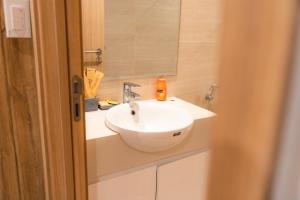 a bathroom with a white sink and a mirror at Susu'home - Căn hộ view biển - Trung tâm Bãi Cháy in Ha Long +4 photos