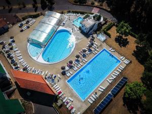 una vista aérea de 2 piscinas con mesas y sillas en LES COTTAGES DE LEON, en Léon
