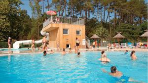 un groupe de personnes dans une piscine dans l'établissement LES COTTAGES DE LEON, à Léon