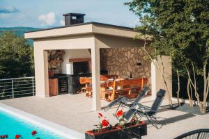 a pavilion with a table and chairs next to a pool at Kuća za odmor Mihaela in Široki Brijeg