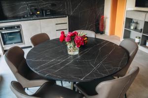 a black marble table with a vase of flowers on it at Kuća za odmor Mihaela in Široki Brijeg