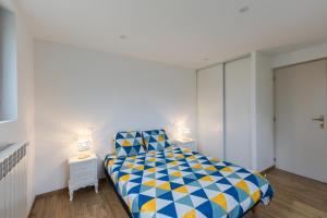 1 dormitorio con 1 cama de color azul y amarillo en Appartement en rez-de-chaussée avec vues sur les montagnes, en Ugine