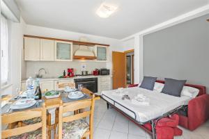 een woonkamer met een bed en een tafel en een keuken bij Casa Elena - Happy Rentals in Riva del Garda