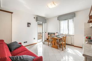 een woonkamer met een rode bank en een tafel bij Casa Elena - Happy Rentals in Riva del Garda