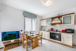 een keuken met een tafel en een tv. bij Casa Elena - Happy Rentals in Riva del Garda