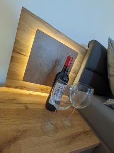 a bottle of wine and two wine glasses on a table at Ferienwohnung Elisabeth in Bischofswiesen