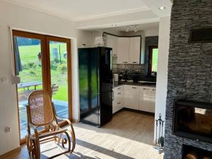 ワプシェ・ニジネにあるLeśny Zakątekの冷蔵庫、椅子、暖炉のあるキッチン +17枚の写真