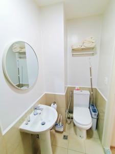 a bathroom with a sink and a toilet and a mirror at The Hive tower D with pool, Wifi, and balcony in Taytay