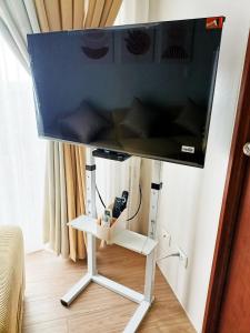 a flat screen tv on a stand in a room at The Hive tower D with pool, Wifi, and balcony in Taytay +17 photos