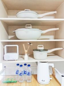 a kitchen shelf with dishes and bottles of water at The Hive tower D with pool, Wifi, and balcony in Taytay