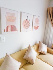a living room with a couch and pictures on the wall at The Hive tower D with pool, Wifi, and balcony in Taytay