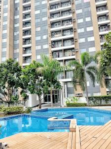 a swimming pool in front of a large apartment building at The Hive tower D with pool, Wifi, and balcony in Taytay