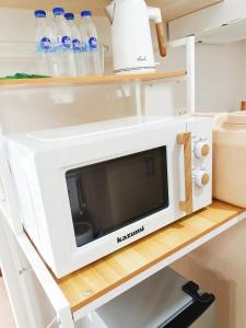 a microwave on a shelf in a kitchen at The Hive tower D with pool, Wifi, and balcony in Taytay
