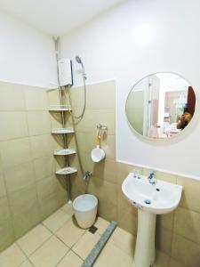 a bathroom with a shower and a sink and a mirror at The Hive tower D with pool, Wifi, and balcony in Taytay