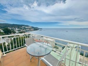 balcón con mesa, sillas y vistas al océano en Marina 4, en Roses