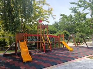 een speeltuin met gele en rode apparatuur in een park bij Apart Hotel Harmony Hills Residence in Rogachevo