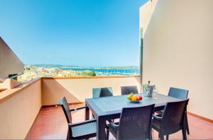 a table and chairs on a balcony with a view at PALAU APARTMENT - HOME and MORE in Palau +13 photos