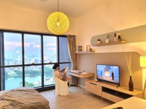 a woman standing in a living room with a television at M city service suite KLCC in Kuala Lumpur +90 photos