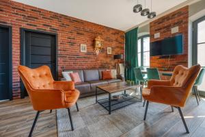 a living room with a couch and chairs at Restored Factory Residence - 55m2, Top Location - by Rentujemy in Łódź