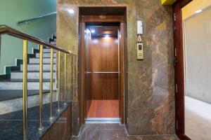 ポンディシェリにあるMartine's Residencyの階段のある建物内の木製エレベータードア