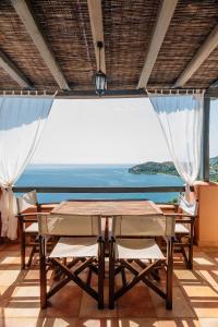 een tafel en stoelen met uitzicht op de oceaan bij Apelon Tiritas Villas in Leonidion