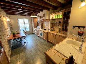 a large kitchen with a sink and a table at Appartement entier 3 chambres hyper centre in Villers-Cotterêts