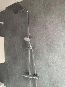 a shower with a shower head in a bathroom at Spacious 2 Bedroom Flat in Leven, Fife, Near St. Andrews in Fife